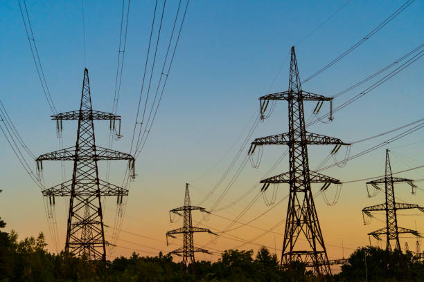 istock High voltage electric tower Silhouette on sunset time, power pylons on sunset time background. 1203126819