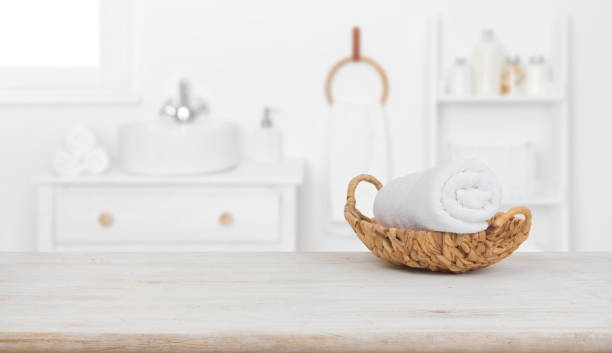istock Towel in basket on wooden table over blurred bathroom background 1203126912