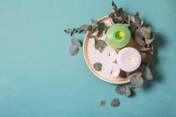 istock eucalyptus leaves and burning candles on blue background 1203129403
