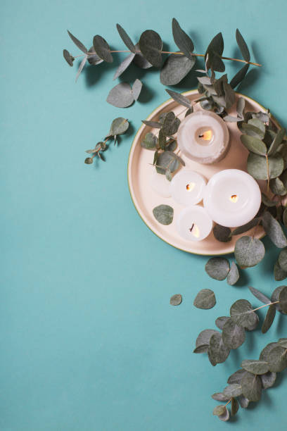 istock eucalyptus leaves and burning candles on blue background 1203129634