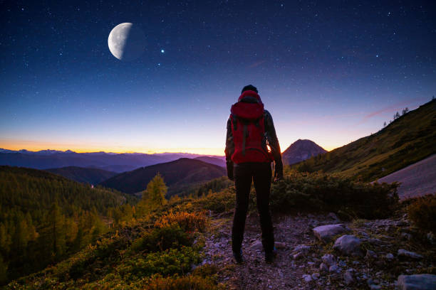 istock woman watching night sky high up in mountains 1203131087