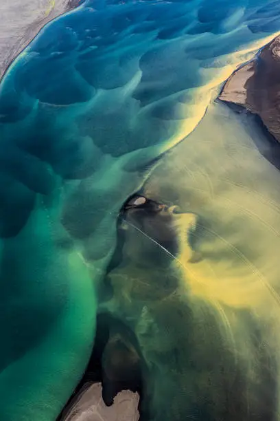 Beautiful Icelandic landscape ornated with flowing glacial rivers, as seen from a helicopter.