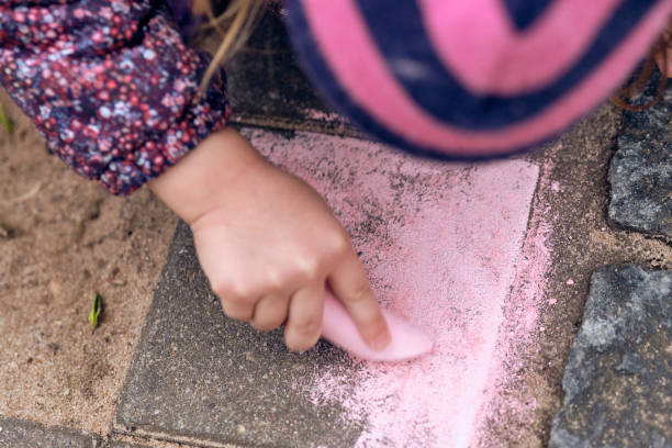 close-up of caucasian child girl drawing with street chalk - sandbox child human hand sand imagens e fotografias de stock