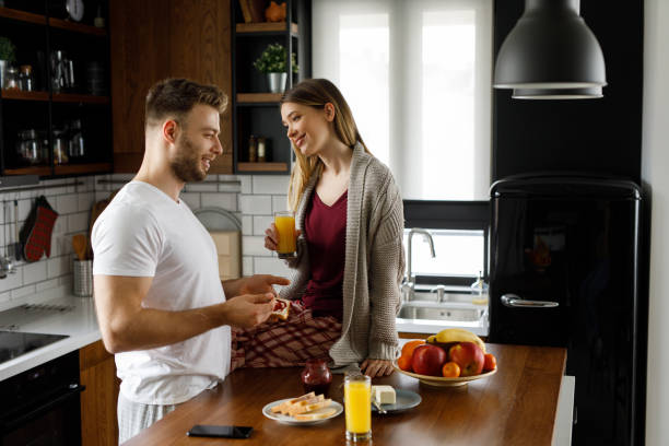 istock Young happy couple eating breakfast in the kitchen 1203133363