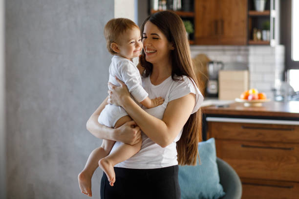 istock Smiling mother holding her baby boy 1203133545