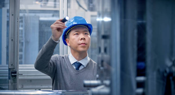 istock Engineer examining manufacturing machinery in factory 1203135875