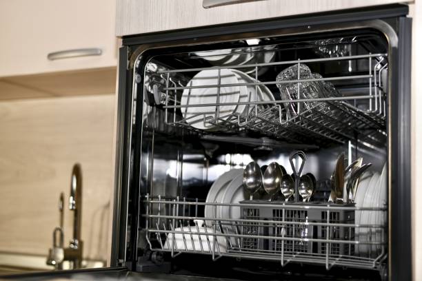 istock A dishwasher with dishes, open, with a view without a door, is installed at the sink level with a dryer and two taps. 1203138478