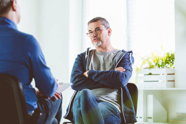 istock Mature man talking with psychotherapist in his office 1203139791