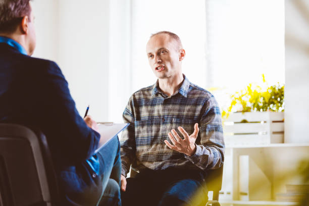istock Mature man talking with psychotherapist in his office 1203139924