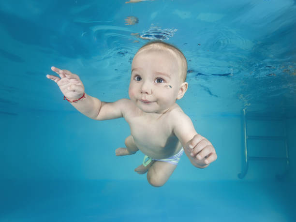 istock Little boy swims underwater in a swimming pool 1203141263