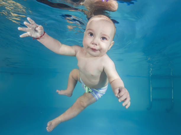 istock Little boy swims underwater in a swimming pool 1203141278