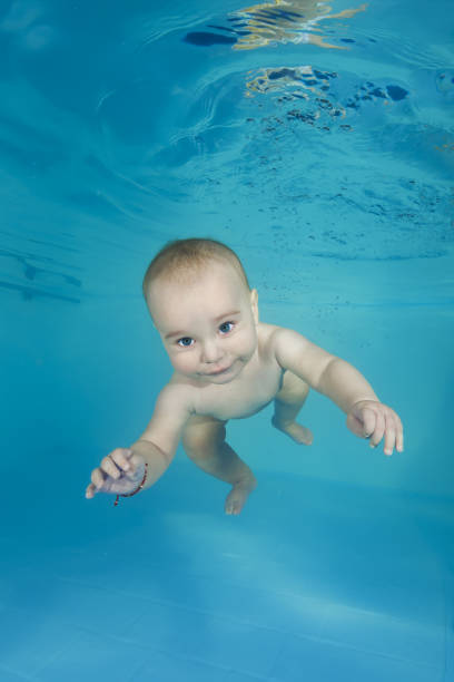 istock Little boy swims underwater in a swimming pool 1203141290