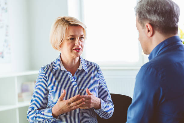 mujer preocupada hablando con psicoterapeuta - men mental illness loss despair fotografías e imágenes de stock