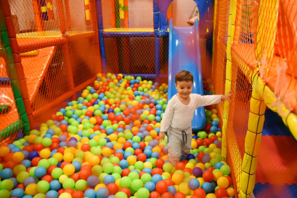 istock Smiling child playing in a colorful ball pit 1203143249