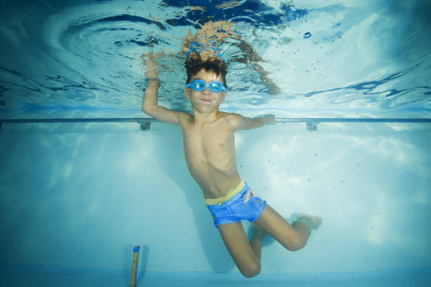 istock A boy in goggles plays underwater in a swimming pool 1203145642