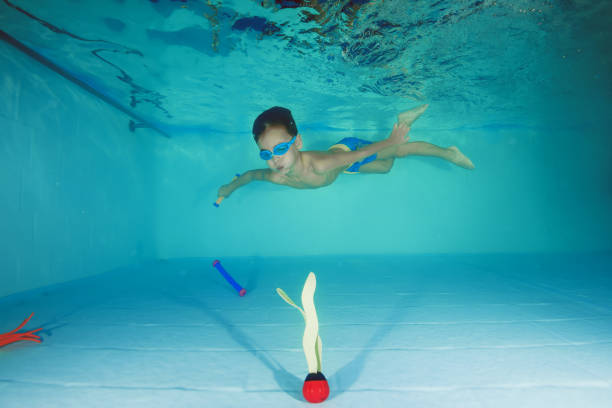 istock A boy in goggles plays underwater in a swimming pool 1203145671
