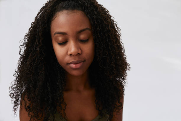 istock Young woman standing with her eyes closed on gray 1203146159