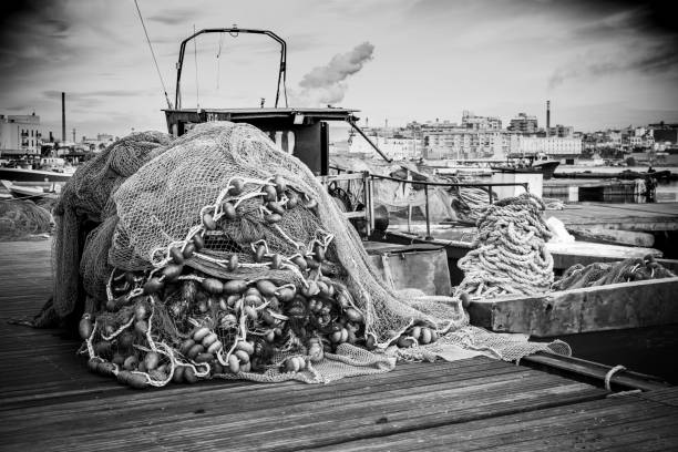 istock Fishing Net accumulated on a berth on Taranto Indusrtial Site Background. Grey Scale Background on Relaxing Italian Place. 1203146198