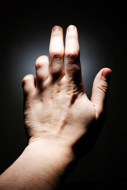 istock male hand on a dark background isolate. copy space close up 1203148313
