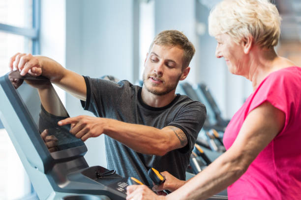 seniorin in rehabilitationsbehandlung - spinning instructor exercising gym stock-fotos und bilder