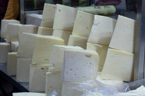 istock Close-up of cheddar cheese is sold in the market. Triangular slice shaped. 1203150229
