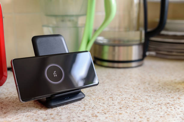 istock smartphone wireless charging on charging stand with 27 percent icon on screen on kitchen tabletop 1203153289