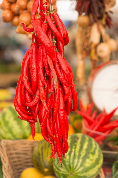 istock Red hot chillies hanging at Market stall 1203155317