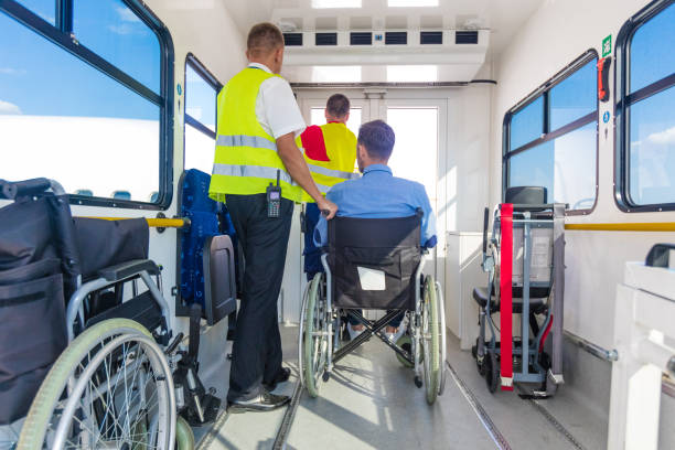 Ground crew helping disabled passenger to enter on board at airport