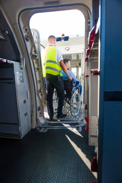 istock Service man helping disabled passenger to enter on board at airport 1203155985