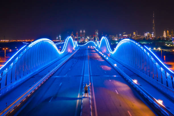 Aerial view of the Meydan Bridge and street road or path way on highway with modern architecture buildings in Dubai Downtown at night, urban city, United Arab Emirates or UAE. Aerial view of the Meydan Bridge and street road or path way on highway with modern architecture buildings in Dubai Downtown at night, urban city, United Arab Emirates or UAE. khalifa stock pictures, royalty-free photos & images