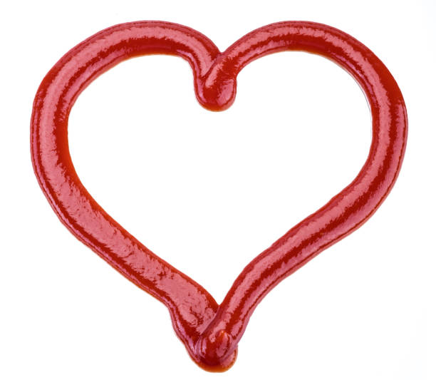 istock Ketchup in a shape of heart on white background. 1203158521