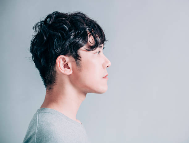 istock side view of young smiling handsome man isolated on gray background 1203159568