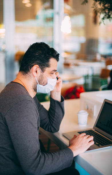 istock Man Wearing Sterile Mask Works in Cafe 1203159652