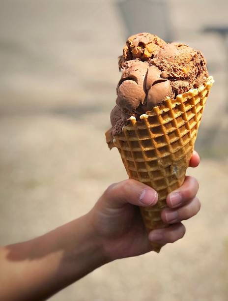 istock Hand holding big scoops ice cream cone 1203159852