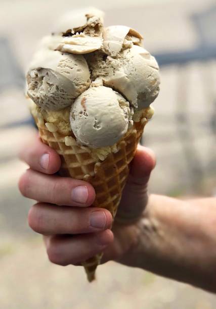 istock Hand holding big scoops ice cream cone 1203159866