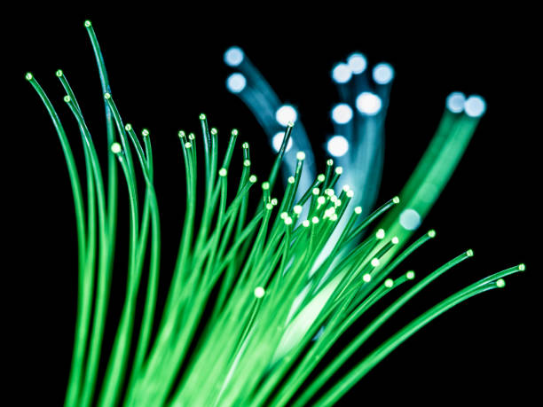 istock Bundle of optical fibers with green light. Black background. 1203160498
