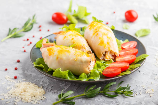 istock stuffed baked squid with greens on a blue ceramic plate on a gray concrete background, side view, close up. 1203160617