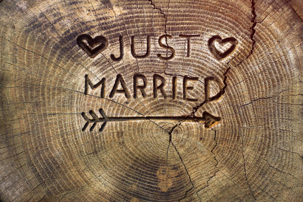 Just married. An inscription on a cut of a tree for a wedding decoration. Handmade decorative board on oak. Photo for your invitation design.