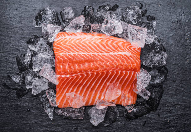 istock Fresh salmon fillet over ice on black cutting board. 1203162176