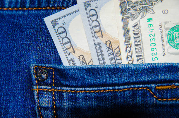 American banknotes in jeans pocket. A note in denominations of $ 100 peeps, stick out from the back, the foremost pants pocket. Money falls out of pocket. Flare effect. View from different angles billetes americanos en bolsillo vaqueros. una nota en denominaciones de $ 100 peeps, sobresalir de la parte posterior, el bolsillo de pantalones más importante. el dinero se cae de su bolsillo. efecto destello. vista desde diferentes ángulos