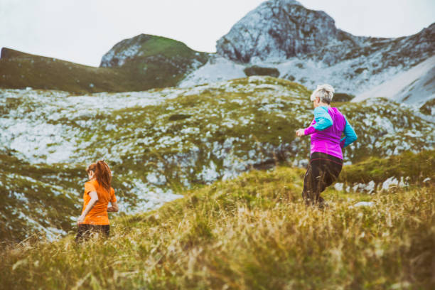 istock Mother and daughter running in the mountains 1203163606