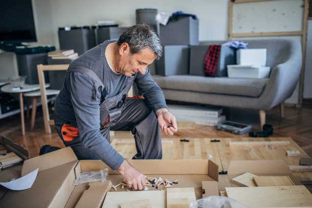istock Man in work suit putting together wooden table 1203165275
