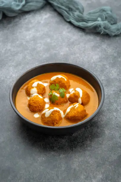 Cheese ball dipped in creamy gravy  and served in bowl