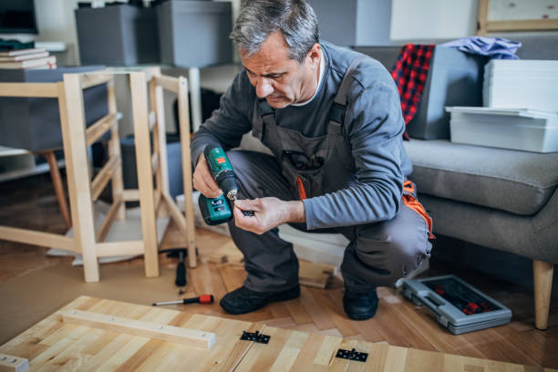 istock Senior man in work suit assembling wooden furniture 1203165357