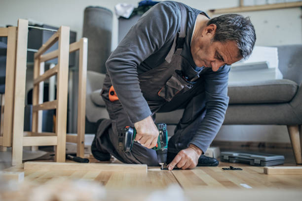 istock One man in work suit assembling wooden furniture 1203165382