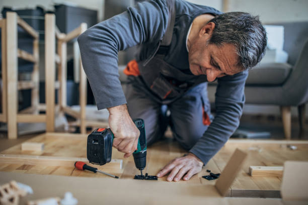 istock Carpenter in work suit assembling wooden furniture 1203165538
