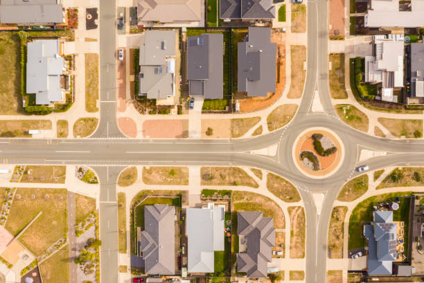 Aerial view of streets, rooftops and a roundabout embellished with landscaping design in the newly established suburb of Coombs in Canberra, Australia stock photo