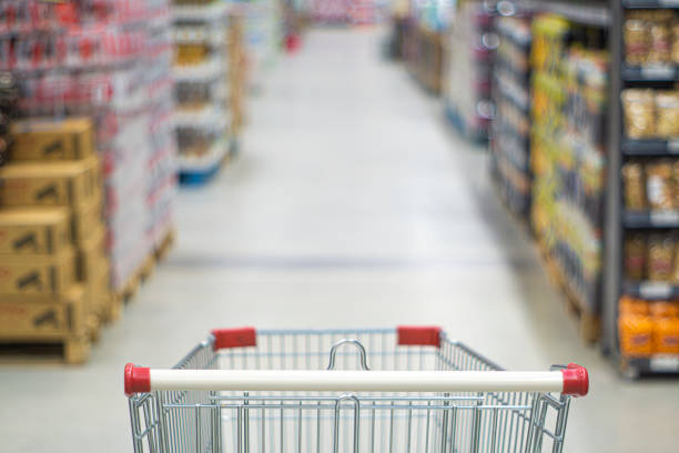 Shopping cart view in Supermarket aisle with product shelves abstract blur defocused background stock photo