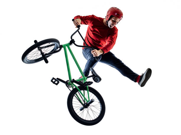 BMX rider cyclist cycling freestyle acrobatic stunt isolated white background one young caucasian man BMX rider cyclist cycling freestyle acrobatic stunt in studio isolated on white background acrobatic activity photos stock pictures, royalty-free photos & images