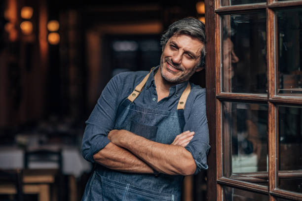 istock Gentleman waiter and cafe owner in his cafe 1203166432